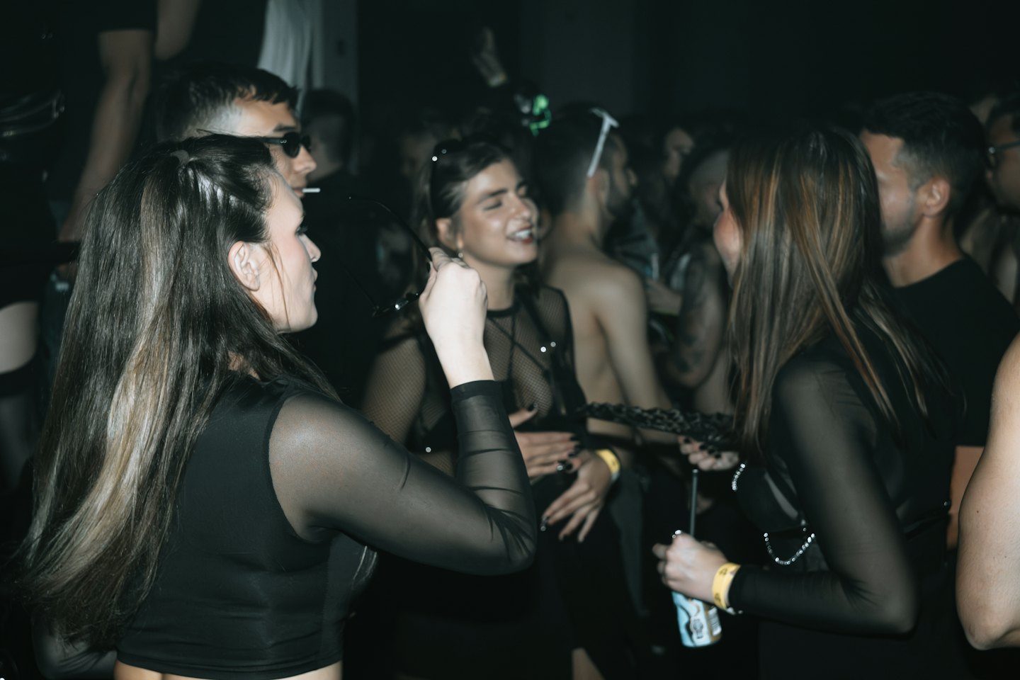 Junge Erwachsene beim Tanzen und Feiern in einem vollen Club.